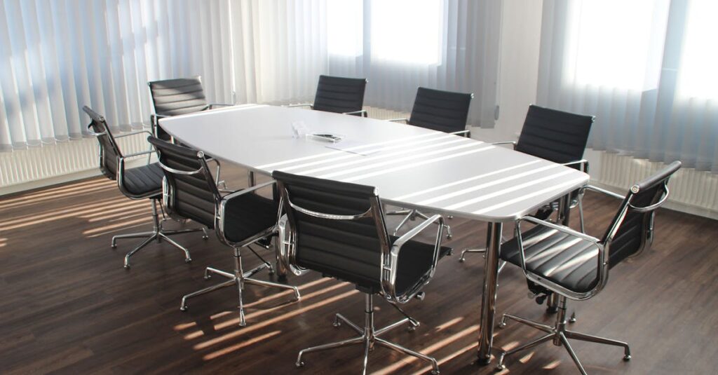 Modern office meeting room with designer chairs, table, and large windows.