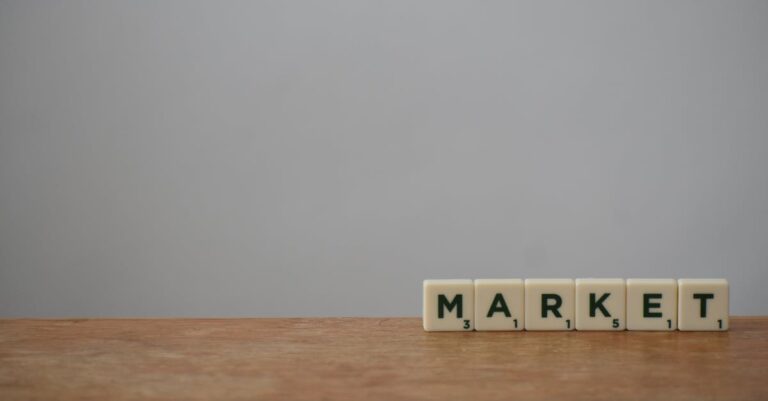 Scrabble tiles spelling 'Market' on a wooden table with a minimalist background.