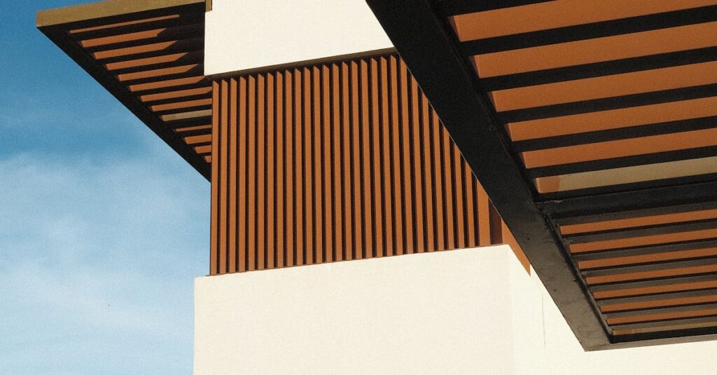 A contemporary building showcasing geometric design and wooden accents against a clear blue sky.