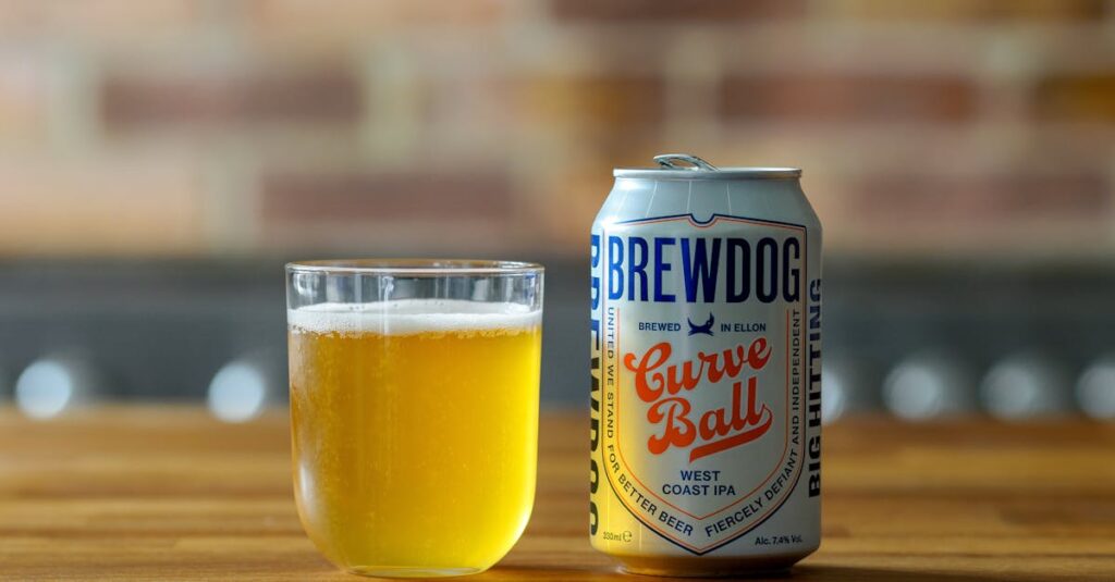Brewdog Curve Ball West Coast IPA in a can with a chilled glass on a wooden table.