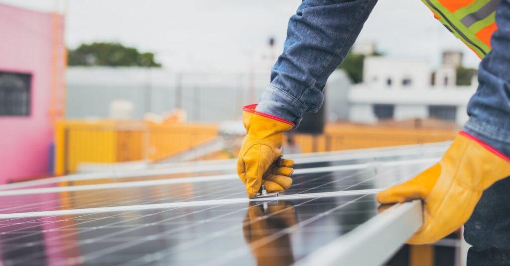 A solar technician performing maintenance on solar panels outdoors.