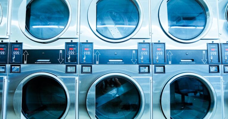A row of modern washing machines in a launderette, showcasing contemporary laundry technology.