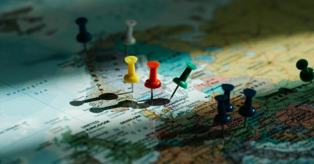 A close-up view of colorful push pins marking locations on a detailed world map.